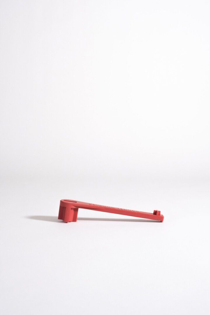 A Red Color Bung Wrench for Large Drum With White Background