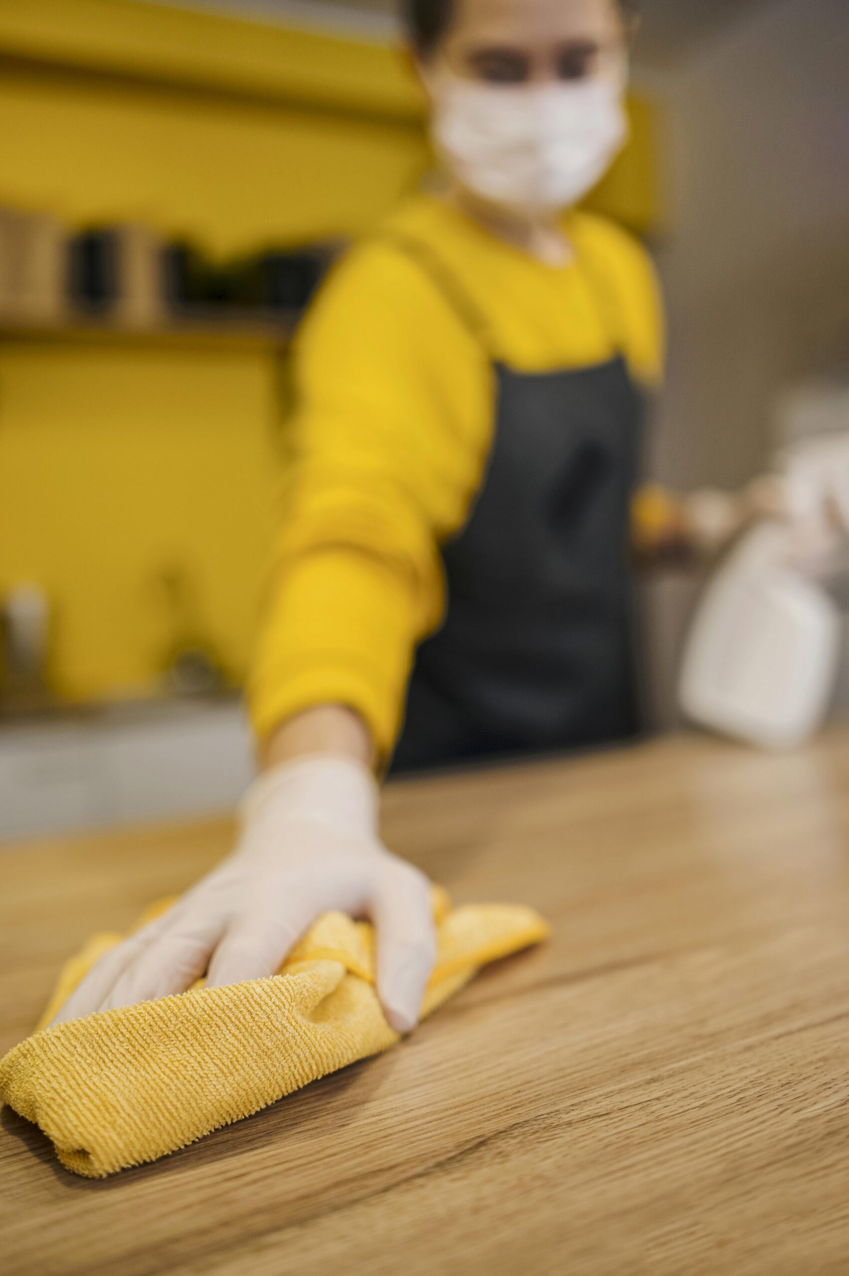 high-angle-defocused-barista-cleaning-surface-while-wearing-medical-mask